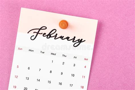 A February 2023 Calendar And Wooden Push Pin On Pink Colour Background