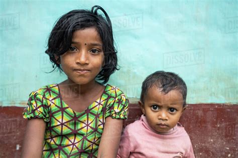 Bangladeshi Sister And Brother Sit In Front Of Their House In Sylhet