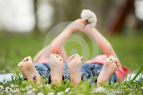 Happy Little Children Lying In The Grass Barefoot Daisies Around