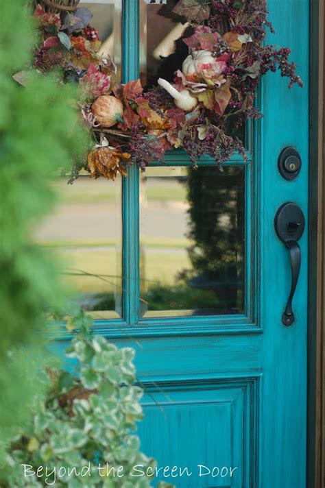 Chic cottage home features taupe siding framing a turquoise front door flanked by sidelights. More Turquoise Front Doors - Sonya Hamilton Designs