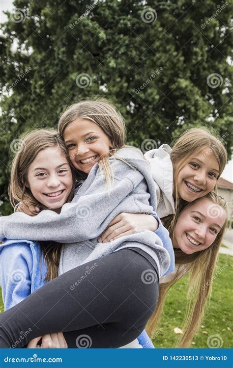 Group Of Teenage Girls Playing And Smiling Together Outdoors Stock