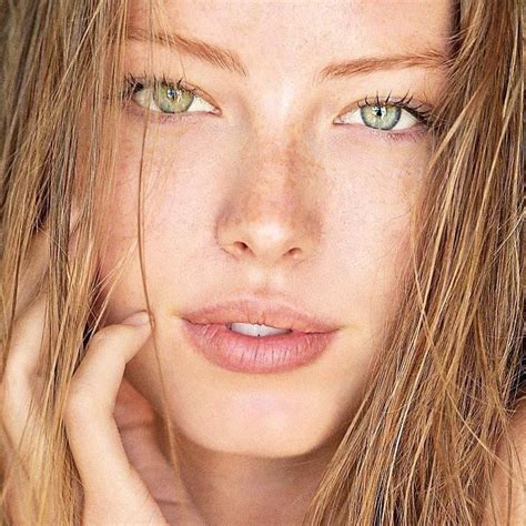 A Woman With Freckled Hair And Green Eyes Is Posing For The Camera