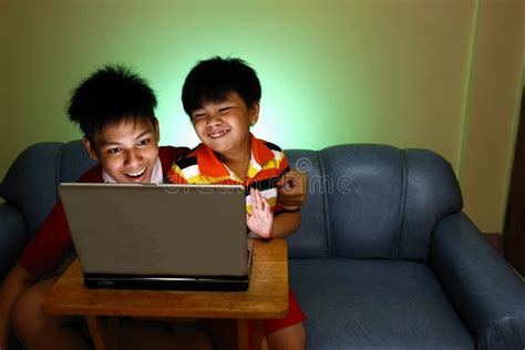 Two Young Boys Using A Laptop Computer And Smiling Stock Image Image