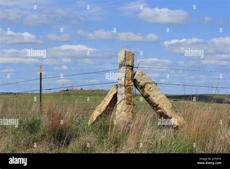 Corner Stone Post Fence In A Pasture With Prairie Grass With Blue Sky