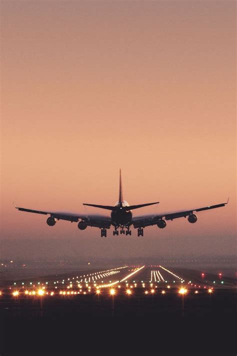An Airplane Is Taking Off From The Runway At Sunset Or Dawn With Its