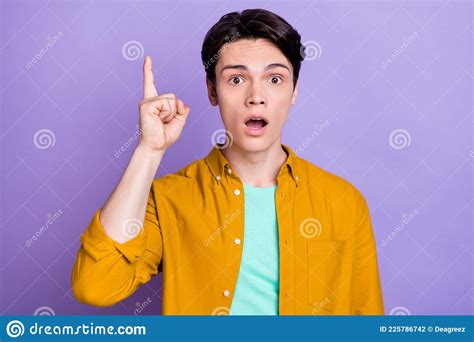 Photo Of Impressed Brunet Millennial Guy Point Up Wear Yellow Shirt