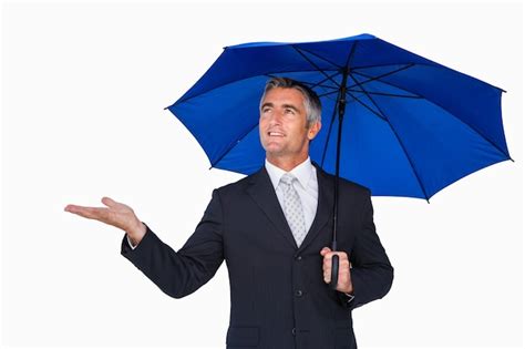 Premium Photo Smiling Businessman Under Umbrella With Hand Out