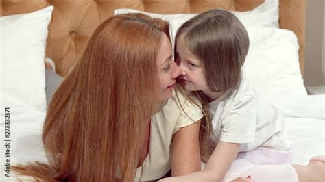 Vidéo Stock Happy mother and daughter rubbing noses resting at home