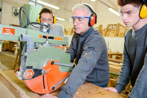 Carpenter Teaching Apprentices How To Use Circular Saw Stock Photo