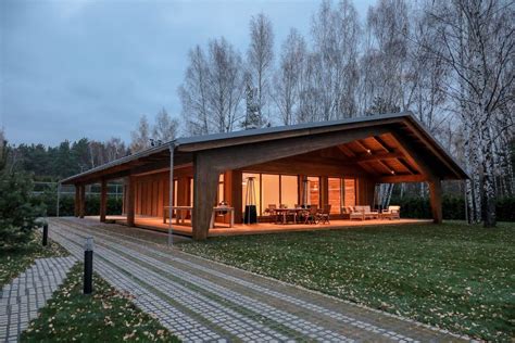 A Small Wooden House Sitting On Top Of A Lush Green Field Next To A Forest