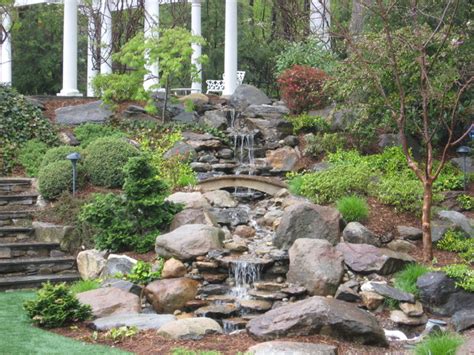 Rock Waterfall And Landscaping On A Slope Rustic Garden