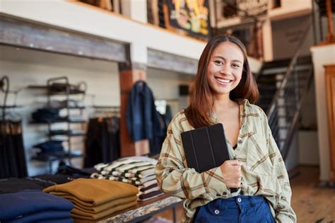 Premium Photo Portrait Of Female Owner Of Fashion Store Using Digital Tablet To Check Stock In