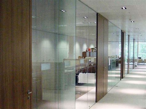 An Office Hallway With Glass Walls And Wooden Doors