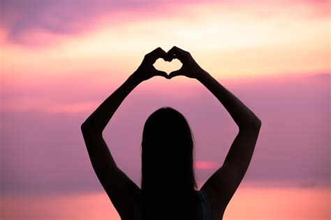 Woman Making A Hand Shaped Heart At Sunset Stock Photo Download Image