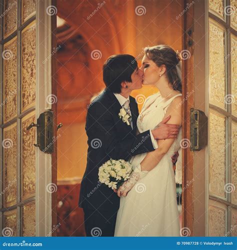 A Tender Kiss Of Newlyweds In The Entrance To The Hall Stock Photo