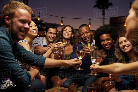 Group Of Friends Enjoying Night Out At Rooftop Bar Stock Photo Dissolve