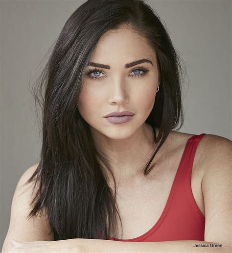 A Woman With Long Dark Hair Wearing A Red Tank Top And Posing For A Photo