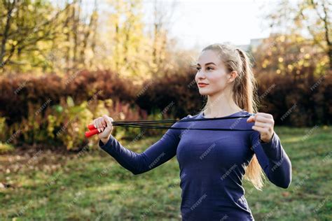 premium photo smiling beautiful blonde girl doing skipping rope outdoors