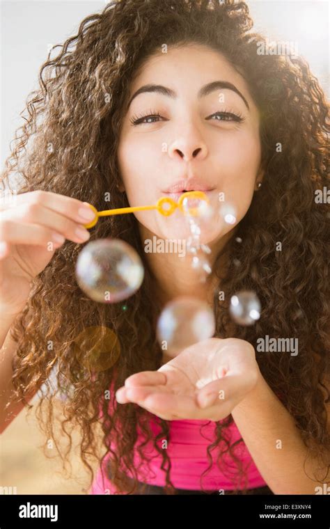 Mixed Race Woman Blowing Bubbles Stock Photo Alamy