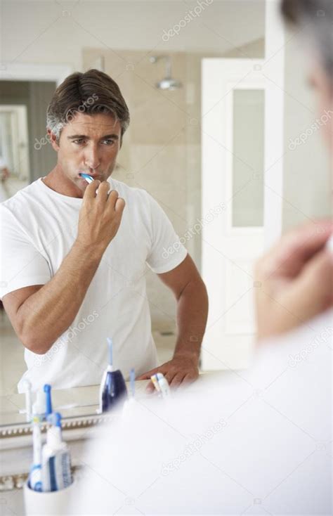 Man Brushing Teeth In Bathroom — Stock Photo © Monkeybusiness 102760124