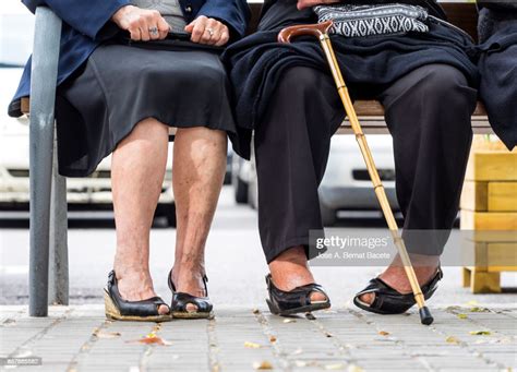 Group Of Two Elderly Women Sitting On A Park Bench In The Street