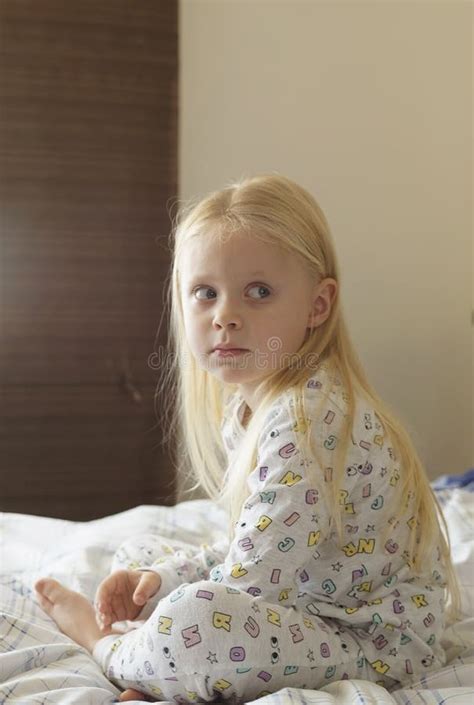 blonde girl in the morning sits on the bed and looks in the frame stock image image of