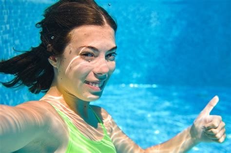 Ребенок плавает под водой в бассейне счастливая активная девочка