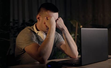 Sleepy Tired Young Male Student Studying Late By The Laptop At Night At