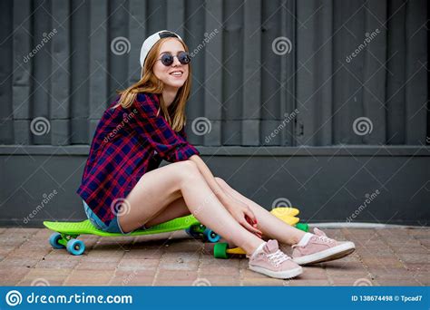 A Pretty Blond Girl Wearing Sunglasses Checkered Shirt And Denim