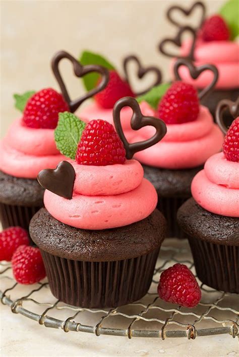 Chocolate Cupcakes With Pink Frosting And Raspberries On Top Are
