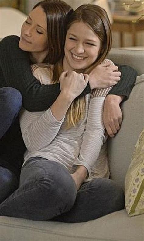 Two Women Sitting On A Couch Hugging Each Other