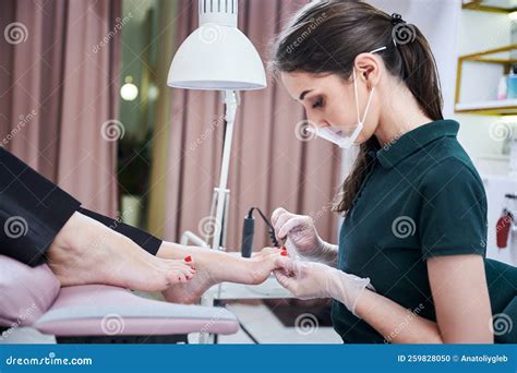 Woman Nail Specialist Doing Pedicure For Client In Beauty Salon Stock