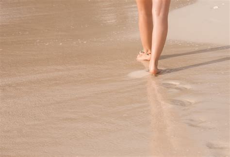 Mujer Caminando Por La Playa Dejando Huellas Foto Premium