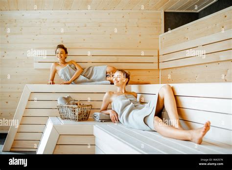Two Young Girlfriends Covered With Sheets Relaxing In The Luxury Sauna