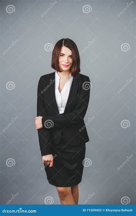 Portrait Of A Beautiful Business Woman Standing Against Grey Background