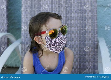 Beautiful Little Girl Wearing A Protective Mask Made Of Fabric With