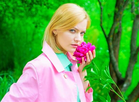 Premium Photo Sensual Woman In Pink Coat With Peony Flower In Park Romantic Girl With Peonies