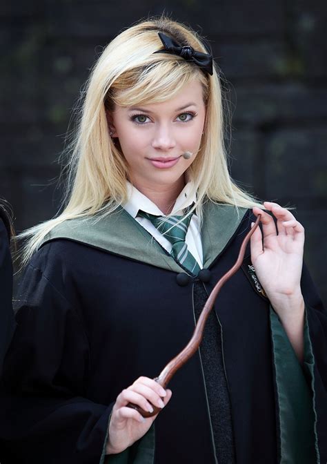 A Woman In A Harry Potter Costume Holding A Wand