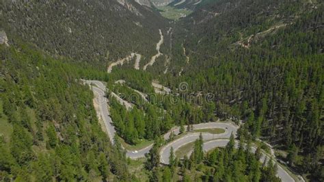 Aerial Flying Above A Switchback Road Winding Through The Dark Green