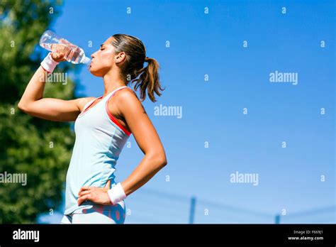 Young Beautiful Athlete Drinking Water After Exercising To Revitalize