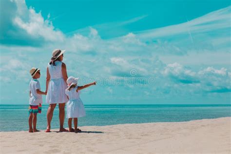 Madre Con Hijo Y Su Hija Caminan Por La Playa Imagen De Archivo