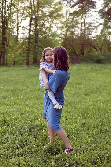 Mother And Daughter In A Blue Dress Are Played In The Spring Photograph