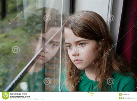 Girl Looking Out A Window With A Sad Expression Stock Photo Image Of