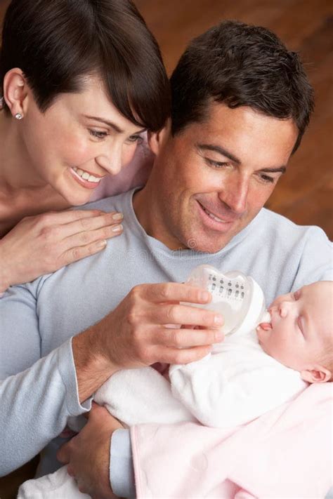 Portrait Of Parents Feeding Newborn Baby At Home Stock Image Image Of