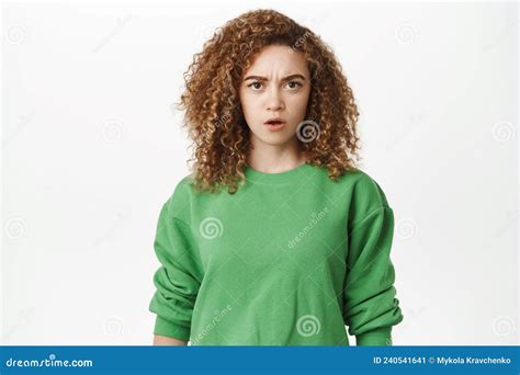 Portrait Of Shocked And Disgusted Young Woman Showing Tongue And Grimacing From Dislike
