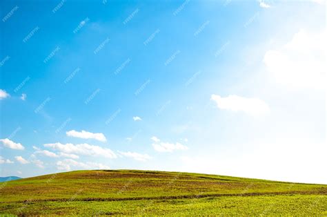 Premium Photo Wide Green Field On Rolling Hills And Blue Sky With Clouds