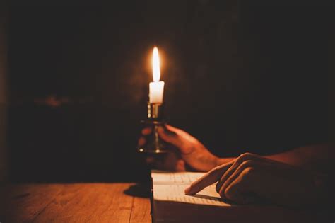 Free Photo Religious Man Holding Lit Candles And Reading The Holy
