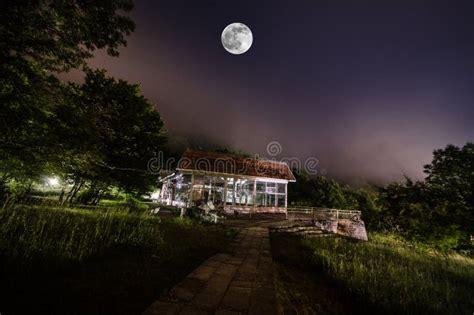 Mountain Night Landscape Of Building At Forest In Foggy Night With Moon