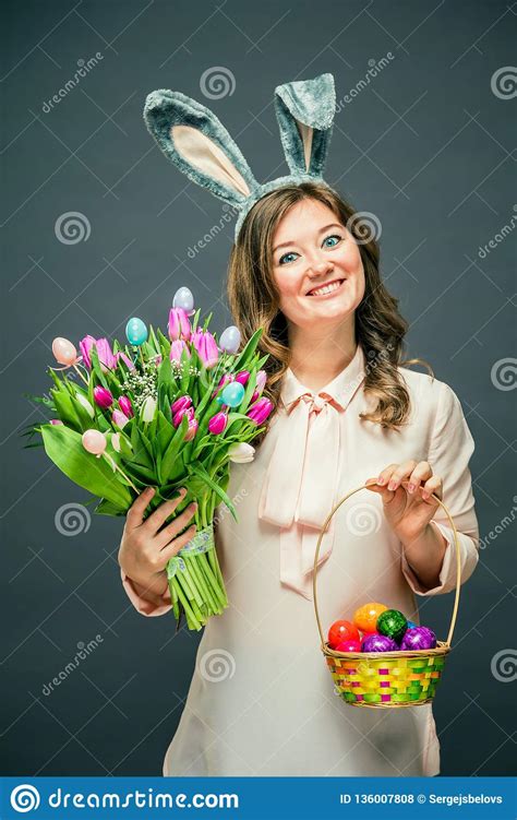 Cheerful Young Woman With Bunny Ears And Easter Egg Basket And Tulips