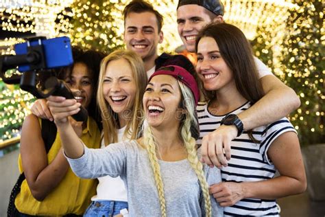 Group Of Young Adult Friends Taking A Group Selfie With A Selfie Stock